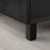 Närbild av mörka trämöbler med metallben på ljust trägolv, som visar robust konstruktion och elegant design.