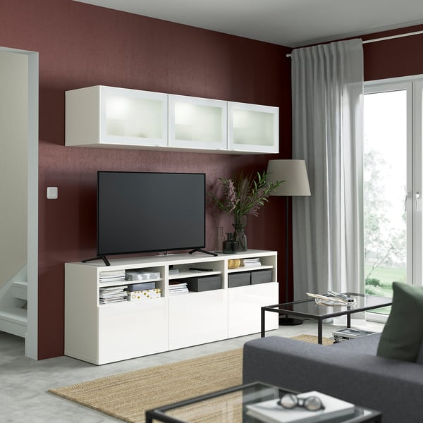 Modernt vardagsrum med platt-tv på BESTÅ-lägenhet, soffa, soffbord och lampa.