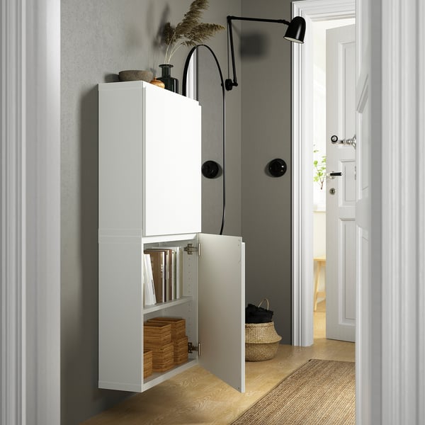 Öppet väggskåp med böcker, korgar, justerbara gångjärn, soft-close, push-open, vägghängt med lampa ovanför.