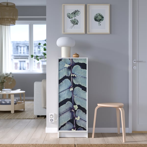 Modernt vardagsrum med lila väggar, bokhylla BILLY med mönstrad dörr, lampa, konst, pall, fönstervy.