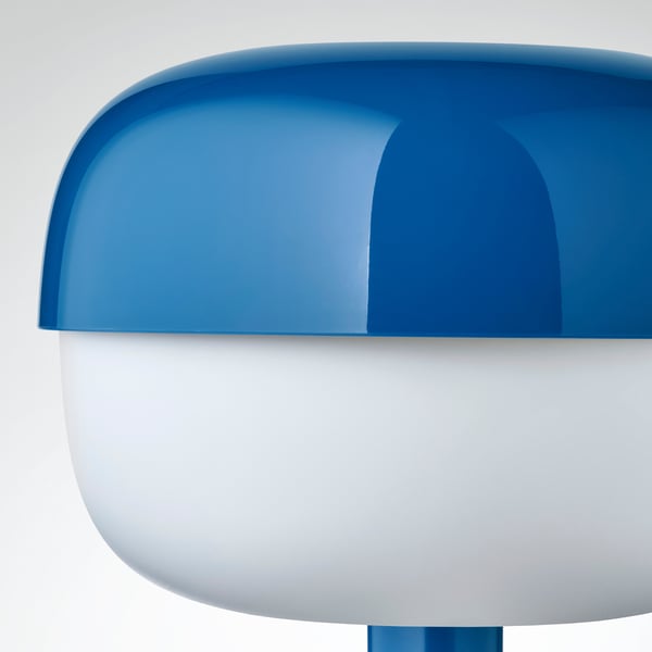 Modern blå bordslampa med mjuk form och retrodesign som ger ett mysigt ljus.
