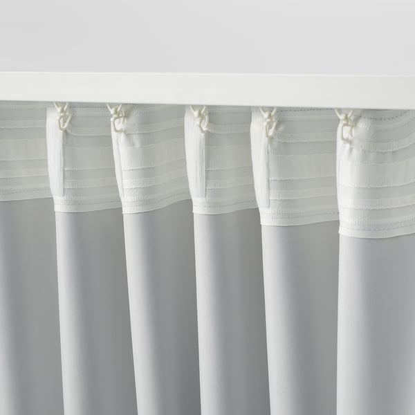 Tre vita gardiner hänger ihop, med en randig skir design upptill, som troligen blockerar ljus och reglerar temperaturen.