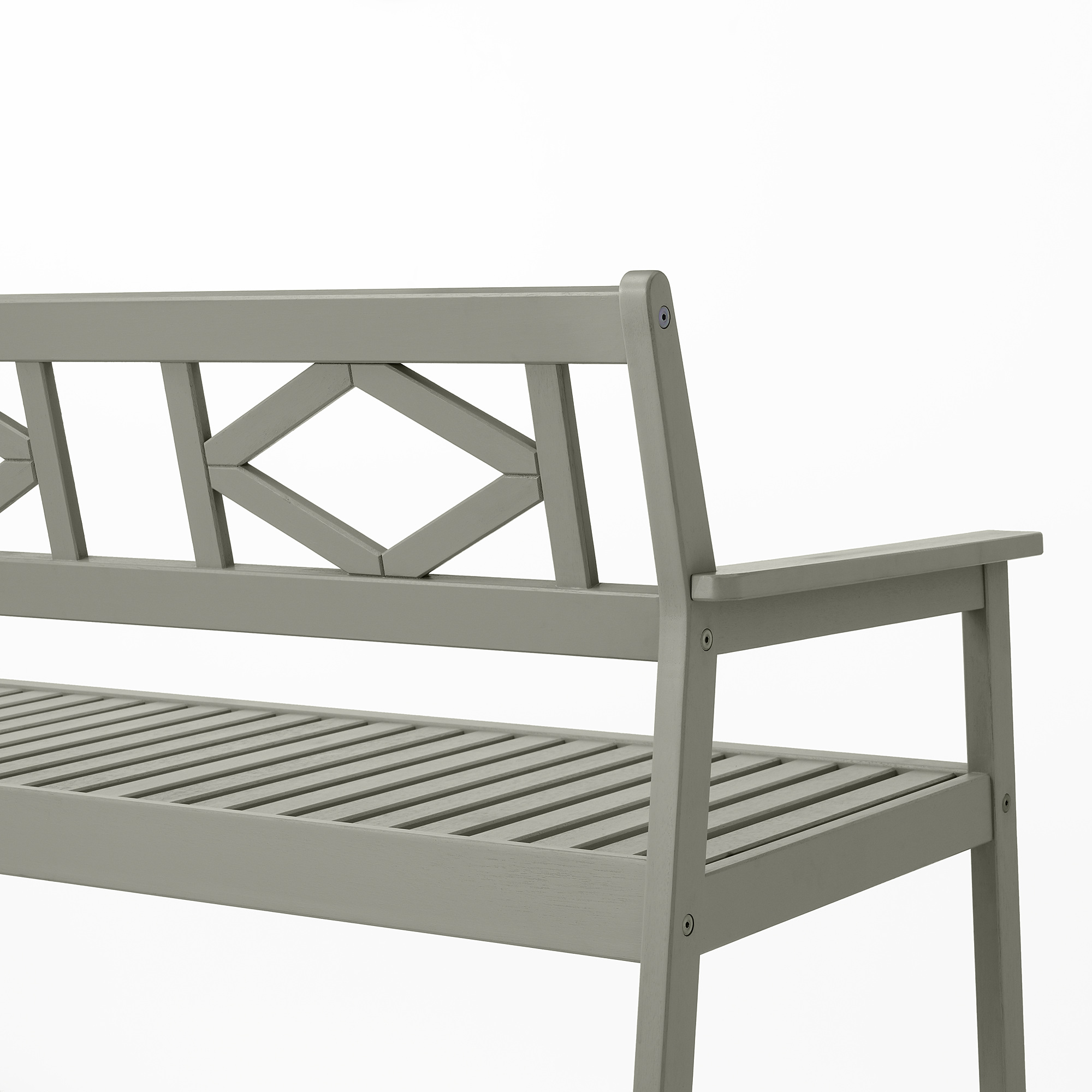 Ljusgrå utomhusbänk med intrikat ryggdesign, robust eukalyptusträ, lamellsits och armstöd, perfekt för komfort och hållbarhet.