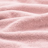 Mjuka rosa handdukar i ekologisk bomull, plysch och strukturerad, vikta snyggt, visar hög kvalitet och absorption.