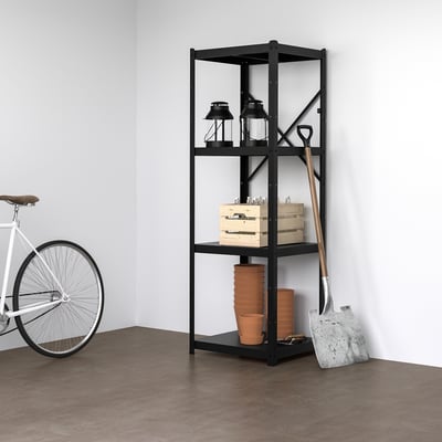 Den svarta hyllan BROR rymmer två lyktor, askar och lerkrukor. Mot den står ett metallverktyg. En vit cykel står i närheten. Minimalistiskt rum.