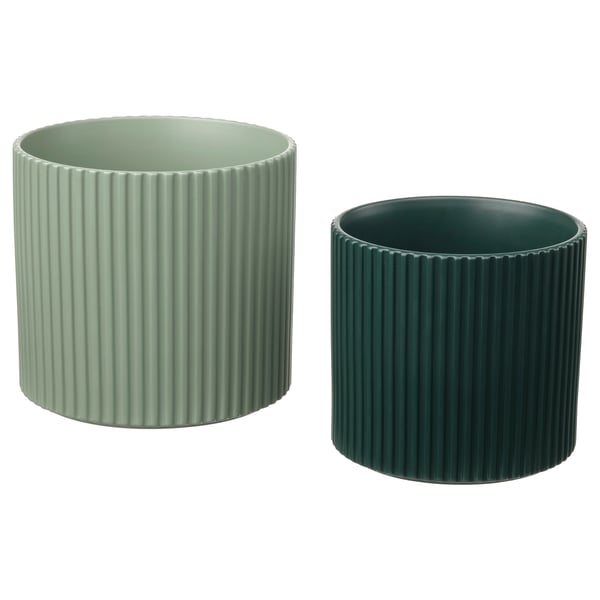 Två moderna krukor, ljus- och mörkgröna, cylindriska med räfflad design, tillverkade av lergods.