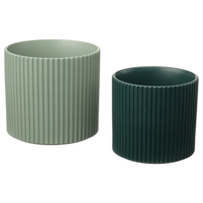 Två moderna krukor, ljus- och mörkgröna, cylindriska med räfflad design, tillverkade av lergods.