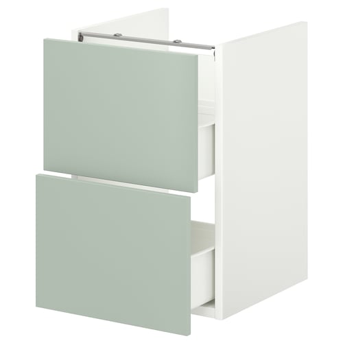 Ett ljusgrönt badrumsskåp från ikea ENHET med två öppna lådor. Skåpet har en elegant, modern design med en slät finish och minimalistiska handtag.