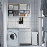 Det lilla, vita skåpet IKEA ENHET passar snyggt under hyllor, med plats för en tvättmaskin och förvaring med tre lådor.