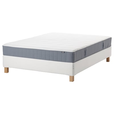 En IKEA ESPEVÄR/VESTERÖY sängbotten och bäddmadrass. Sängbottnen är vit med träben som bär upp en ljusgrå madrass med en quiltad design.