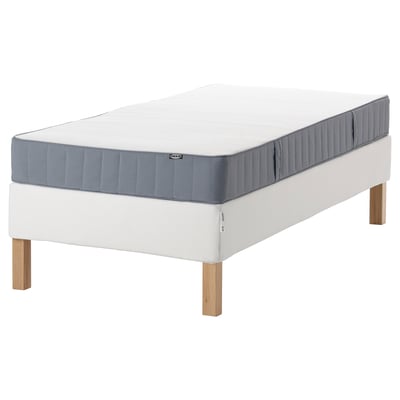 IKEA vit och blå madrass på sängramen. Modern design med träben, medelhög fasthet, motorhuvsfjädrar och slätt tygöverdrag.