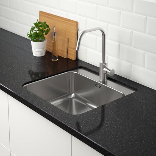 Rostfri diskho med modern kran på svart bänk, snygg installation. Plantera och skärbrädor ovanpå.