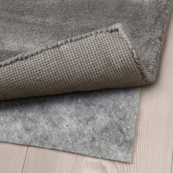 Grå strukturmatta med halkfri filtbaksida, designad för komfort och säkerhet.