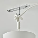 Silverfärgad takkrok med vit kabel som fäster lampan i taket.