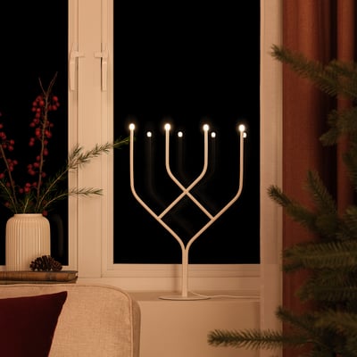 Led kandelabrar med varmvitt ljus, vilket skapar mysig atmosfär, på bordet i vardagsrummet.