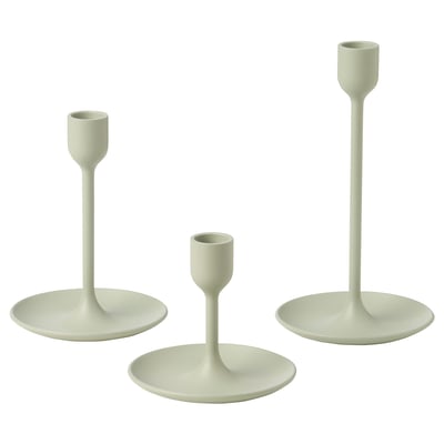 Tre ljusgröna ljusstakar i olika höjder, enkel modern design, gjord av aluminium med filtkuddar, arrangerade i en triangel.