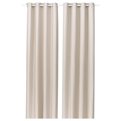 Två beige gardiner hänger rakt med öljettdesign, vilket ger avskildhet och ljusspridning.