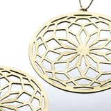 Gyllene dekorativa sfärer med intrikata blommiga utskärningar. Den ena hänger synligt och visar upp fint hantverk och delikat design.