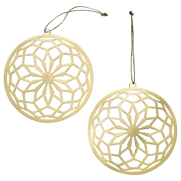 Två guldiga, runda, hängande ornament med intrikata utskurna blommönster, gjorda av rostfritt stål med jutesnöre.