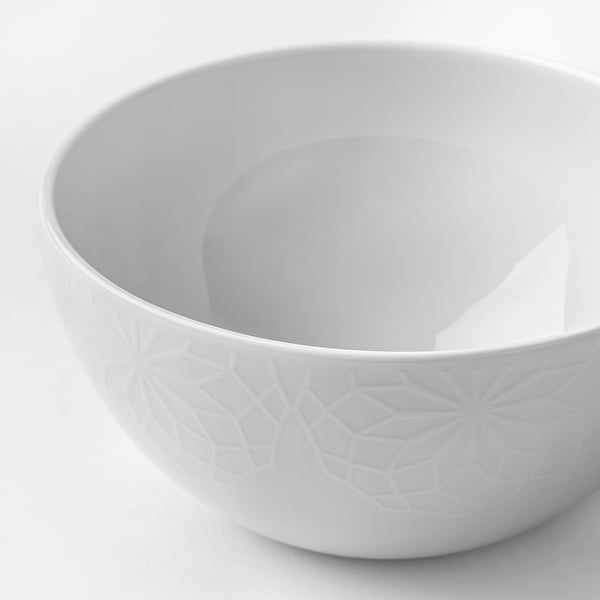 Elegant vit porslinsskål med präglat geometriskt mönster, rätter rent.