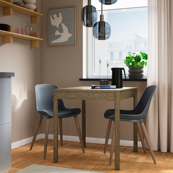 Liten grå GRÖNSTA-matsal med formformade säten och träben, med modern design nära ett fönster.