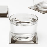 Glas på metalliskt underlägg; Skyddar ytor, minskar buller.
