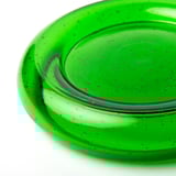 Närbild av ljusstake i återvunnet grönt glas, som visar upp dess släta, livfulla yta och subtila luftbubblor.
