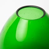 Ljusgrön vas i återvunnet glas med en tjock pärlkant. Slät, rundad kropp som visar naturliga luftbubblor, vilket indikerar handgjord kvalitet.