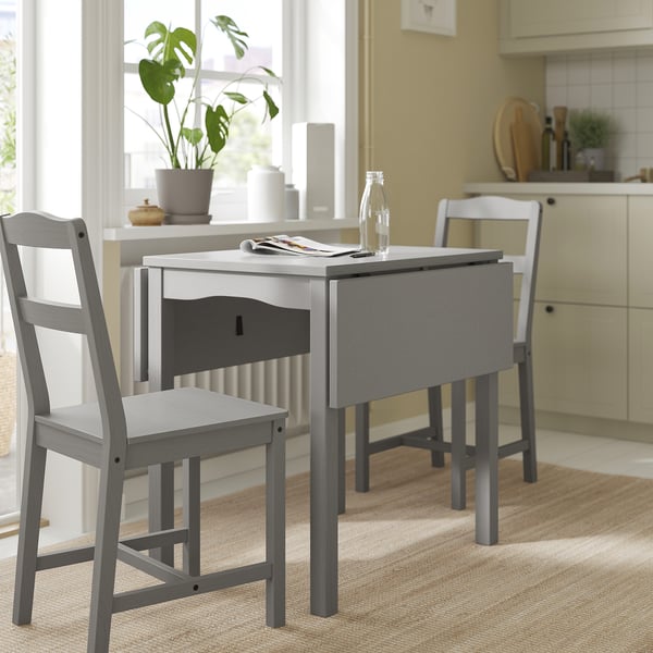 Minimalistisk köksinredning med grått klaffbord och stolar HAUGA. Kompakt design, trämaterial och modern estetik.