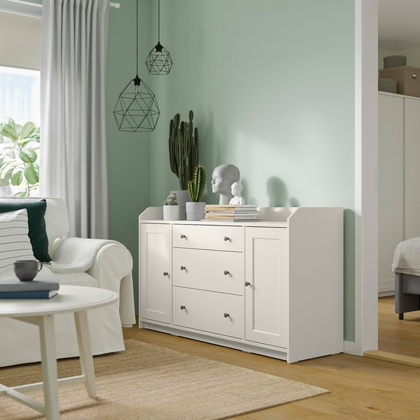 Modernt vardagsrum med vitt HAUGA sideboard, kaktus och hängande lampor.