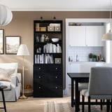 Svart HAVSTA förvaringsmöbel med hyllor och lådor, som blandar skandinavisk design och modern funktionalitet, perfekt för vardagsrum och matplats.