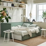 HEMNES grågrön dagbädd med förvaringslådor, omvandlas till en dubbelsäng, skummadrass, lackerad ram. Bredvid bord med växt, rumsinredning.