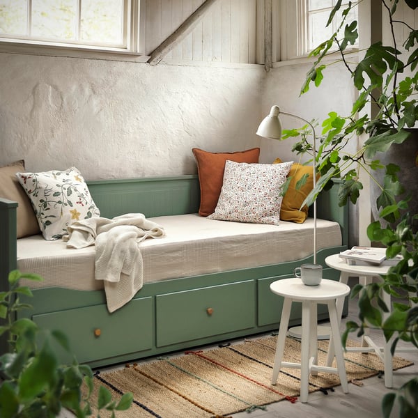 Mysig grön HEMNES dagbädd med lådor och kuddar, vid fönster och växter.