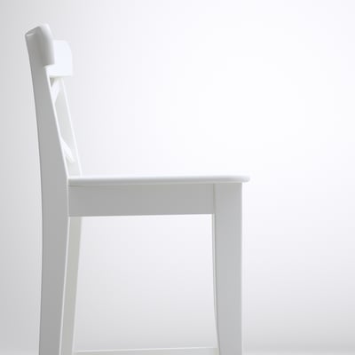 En elegant vit stol som visas i profil, med rena linjer och robust träram, som framhäver kvalitet och minimalistisk design.