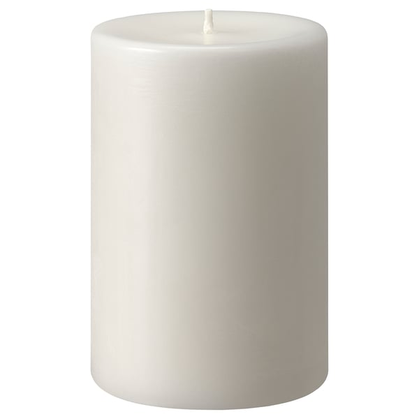 Detta är ett vitt, cylindriskt JUBLA-ljus med en slät yta, tillverkat av stearin, som står upprätt med en veke i toppen.