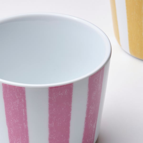Livfull rosa- och vitrandig mugg, tillverkad av slitstarkt porslin.