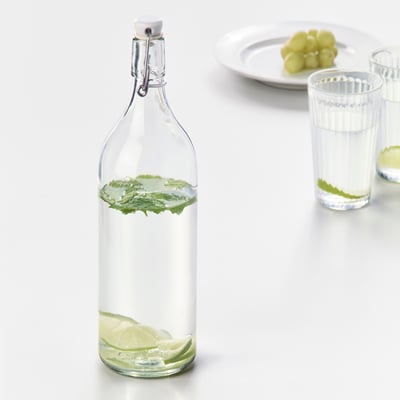 Glasflaska med limeskivor och mynta, förseglad propp.