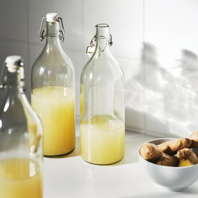 KORKEN: klar glasflaska med silvertrådklämma och vit propp.