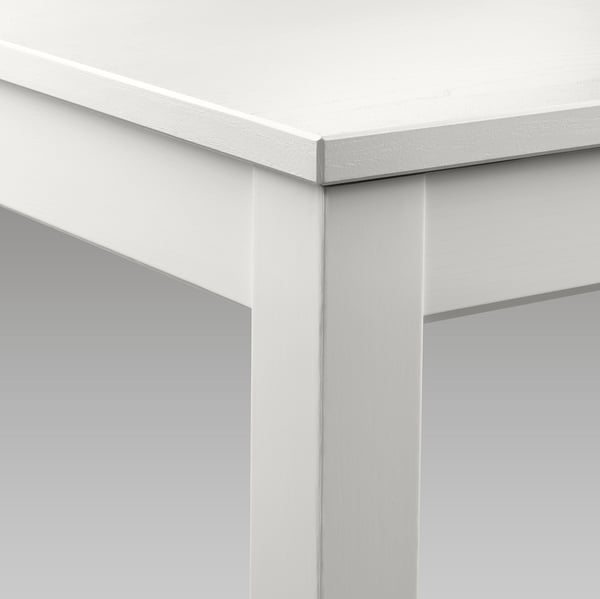 Minimalistiskt vitt matbord, robust träkonstruktion, sömlös förlängningsfunktion.