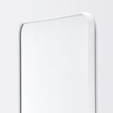 Modern rektangulär spegel med elegant vit ram, monterad på väggen, reflekterar ljus för ett rent, minimalistiskt utseende.