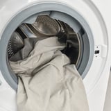 Visar en tvättmaskintrumma med en ljus textil inuti.