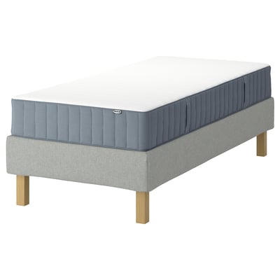 IKEA-madrass och bas, vit ovandel, blå underdel, träben, platt fyrkantig design.