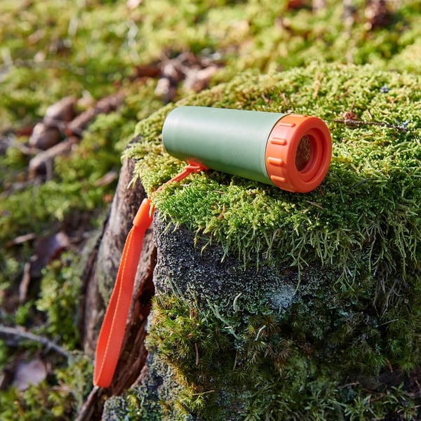Grön och orange mini monokulär vilar på mossbeklädd trädgren. Hållbar, kompakt design som är idealisk för utomhusbruk.