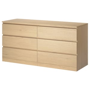 En byrå MALM i ek med sex smidiga lådor, en ren och minimalistisk design som är idealisk för förvaring i sovrummet.