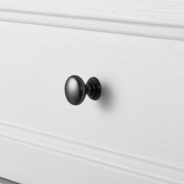 En närbild av en vit låda med ett elegant svart handtag som visar upp högkvalitativ design och finish.