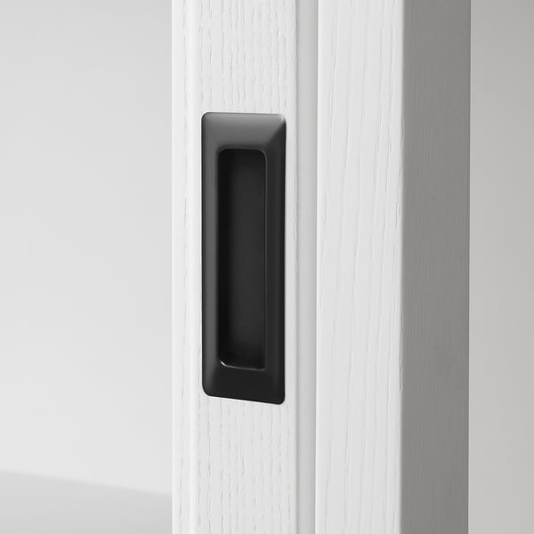 Modernt skåp med elegant handtag, tillverkat av högkvalitativa material. Mörkt handtag står i kontrast till den ljusa, släta ytan. Välgjord, snygg design.