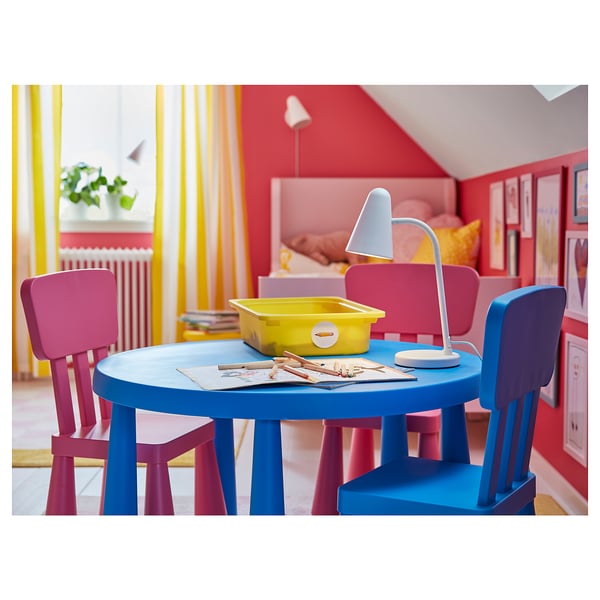 Färgrikt utomhusbord för barn med blått bord, rosa och lila stolar, med en ljusgul behållare och en vit lampa.