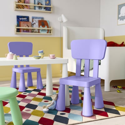Lekplats för barn med lila MAMMUT-stolar, vitt bord, färgglad matta och leksaksuppsättning; Lila stolar är små och lätta.