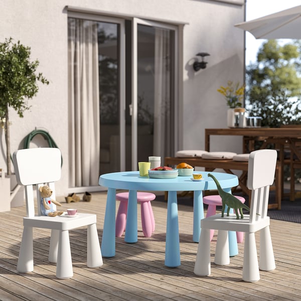 Liten utomhuslekställning för barn med blått bord, vita och rosa stolar. Lätt plast, perfekt för picknick.