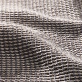 Närbild av texturerad tygblandning, ljusgrå. Intrikat vävmönster synligt, vilket framhäver kvalitet och absorptionsförmåga.